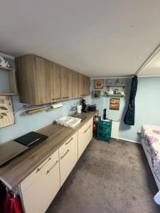 a kitchen with white cabinets and a bed in a room at Ostsee Ferienhaus mit Whirlpool in Wolgast