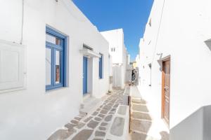 an alley with white houses and blue windows at Chiara Mykonos in Mýkonos City