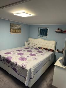 a bedroom with a bed with a purple and white comforter at Ostsee Ferienhaus mit Whirlpool in Wolgast