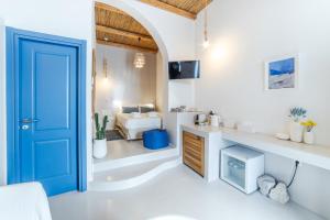 a blue door in a white room with a bedroom at Chiara Mykonos in Mikonos