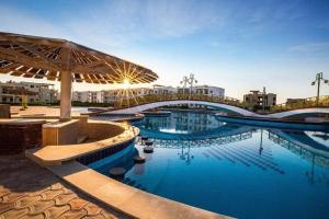 a large swimming pool with a bridge in a city at Golden beach 2 Ras sedr Cozy chalet in Ras Sedr