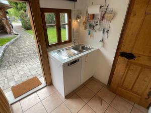 eine kleine Küche mit einem Waschbecken und einem Fenster in der Unterkunft Ferienhaus Judie in Lechbruck