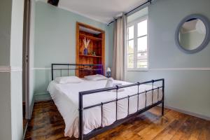 1 dormitorio con cama, espejo y ventana en le romantique, hyper centre, en Périgueux
