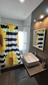 baño con lavabo y cortina de ducha en El Huerto Hostel, en Ica