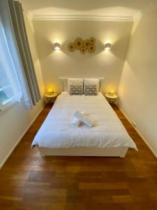 um quarto com uma grande cama branca e 2 candeeiros em Maisons Alfort - Cosy appartement em Maisons-Alfort