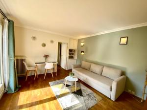 uma sala de estar com um sofá e uma mesa em Maisons Alfort - Cosy appartement em Maisons-Alfort
