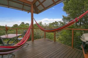 a hammock on a deck with a table at Tallaringa Views in Alstonville