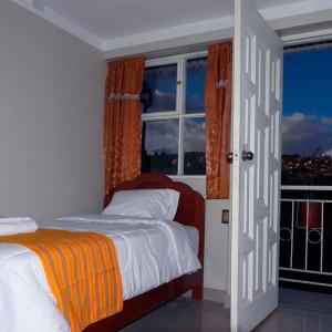 1 dormitorio con cama y ventana en Kuelap Guest House en Chachapoyas