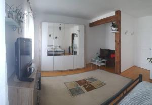 uma sala de estar com uma televisão de ecrã plano e um quarto com em Ferienhaus für 10 Personen in Ulrichsberg, Oberösterreich Mühlviertel em Ulrichsberg