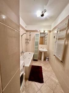 a bathroom with a tub and a sink and a toilet at City center apartment with balcony in Budapest