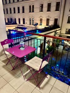 y balcón con mesa y sillas rosas. en City center apartment with balcony en Budapest