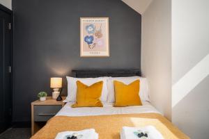 ein Schlafzimmer mit einem Bett mit orangefarbenen Kissen in der Unterkunft Private En-suite Room - Shared Living space & Kitchen - Wakefield - Central in Wakefield