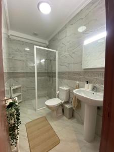 a white bathroom with a toilet and a sink at Mini villa Al hoceima in Al Hoceïma