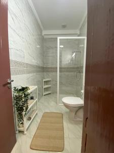 bagno bianco con servizi igienici e doccia di Mini villa Al hoceima ad Al-Ḥoseyma