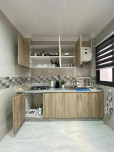 uma cozinha com armários de madeira e um micro-ondas em Mini villa Al hoceima em Al Hoceïma