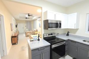 a kitchen with black appliances and a living room at SeaJam Vacation Home between Negril & Montego Bay in Point