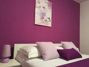 um quarto com uma parede roxa e uma cama com almofadas em Studio für 10 Personen in Lozice auf Vir, Dalmatien Inseln vor Zadar em Lozice