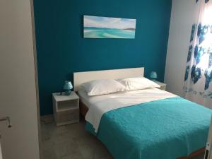 um quarto com uma cama com uma parede azul em Studio für 10 Personen in Lozice auf Vir, Dalmatien Inseln vor Zadar em Lozice