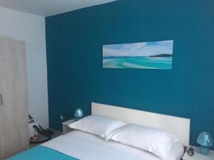 um quarto com uma cama com uma parede azul em Studio für 10 Personen in Lozice auf Vir, Dalmatien Inseln vor Zadar em Lozice