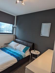 a small bedroom with a bed and a table at The Pinnacle 4/5 in Glasgow