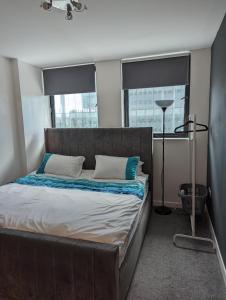 a bedroom with a large bed with two windows at The Pinnacle 4/5 in Glasgow