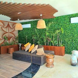 トゥルムにあるLuxury Condo in the Heart of Tulum!!の緑の壁のリビングルーム(ソファ付) +3枚の写真