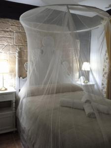 ein weißes Bett mit Baldachin in einem Schlafzimmer in der Unterkunft Casa Rural Montepinar in El Bosque