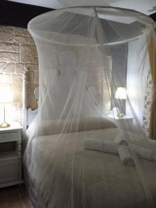 a white bed with a canopy in a bedroom at Casa Rural Montepinar in El Bosque