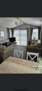 a living room with couches and a table at 6 birth caravan chapel st Leonards trunch lane in Chapel Saint Leonards