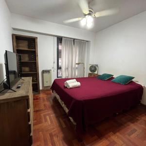 1 dormitorio con 1 cama grande y TV en Montevideo 20 Bis en Córdoba