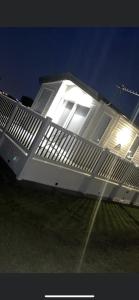 Casa blanca con ventana iluminada por la noche en 6 birth caravan chapel st Leonards trunch lane en Chapel Saint Leonards