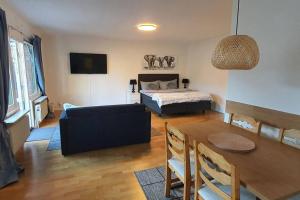 a living room with a couch and a table and a bed at Apartment with garden near metro! in Stockholm