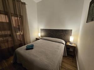 a small bedroom with a bed and two lamps at La Casa di Ray e Anto in Cassibile