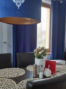 a dining room with a table with a blue wall at Ferienhaus für 8 Personen und 2 Kinder in Kiczora, Schlesien in Milówka