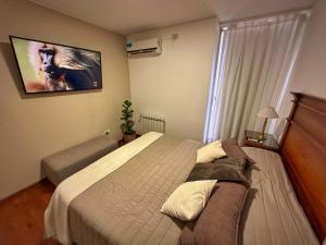 a bedroom with a bed and a tv on the wall at Simplemente DUOMO in Córdoba