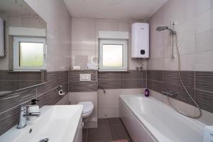a bathroom with a tub and a toilet and a sink at M&M Pelivan apartment in Kaštela +32 photos