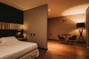 Schlafzimmer mit einem Bett, einem Tisch und Stühlen in der Unterkunft Catuai Hotel in Cacoal