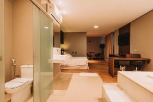 uma casa de banho com WC e uma cama num quarto em Catuai Hotel em Cacoal
