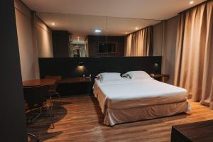 um quarto de hotel com uma cama e uma mesa em Catuai Hotel em Cacoal