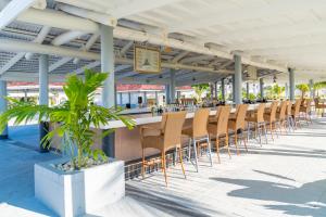 a row of chairs sitting at a bar on the beach at Jolly Beach Antigua - All Inclusive in Bolans