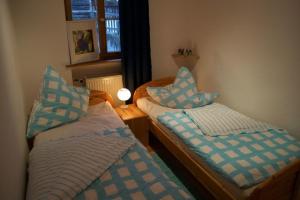 2 camas en una habitación con almohadas azules y blancas en Ferienhaus Sefi en Lechbruck