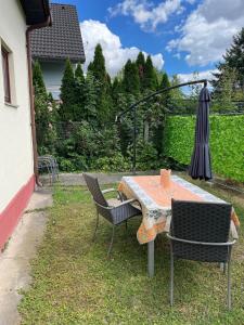 un tavolo e sedie in cortile con ombrellone di Ferienhaus für 6 Personen in Bezirk 23-Liesing, Wien und Umgebung 