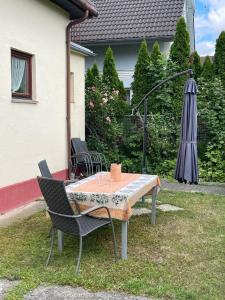 un tavolo con sedie e un ombrellone in un cortile di Ferienhaus für 6 Personen in Bezirk 23-Liesing, Wien und Umgebung 