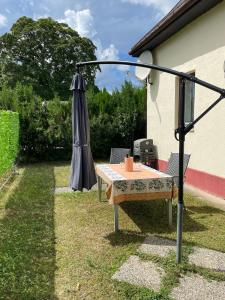un tavolo e un ombrello in un cortile di Ferienhaus für 6 Personen in Bezirk 23-Liesing, Wien und Umgebung 