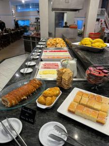 um buffet com diferentes tipos de alimentos sobre uma mesa em Hotel Minorus em Aparecida
