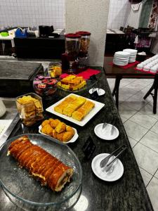 uma mesa com comida e pratos de comida em Hotel Minorus em Aparecida