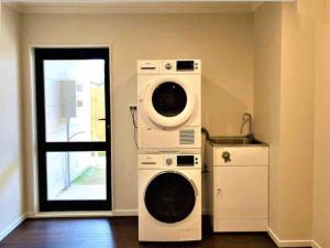 um quarto com duas máquinas de lavar roupa e uma janela em 4 En-suite Rooms Town House em Hamilton