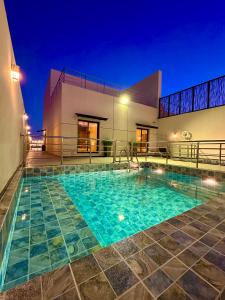 a swimming pool in front of a building at night at شاليهات كابري وماديرا درة العروس in Durat Alarous