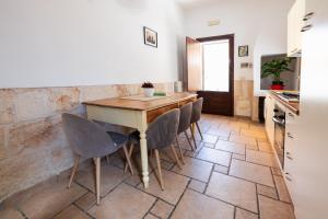 kuchnia z drewnianym stołem i krzesłami w obiekcie CASA LAPILLI w mieście Polignano a Mare