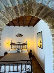 una camera con un letto in una parete in pietra di O Mylos a Ermoupoli